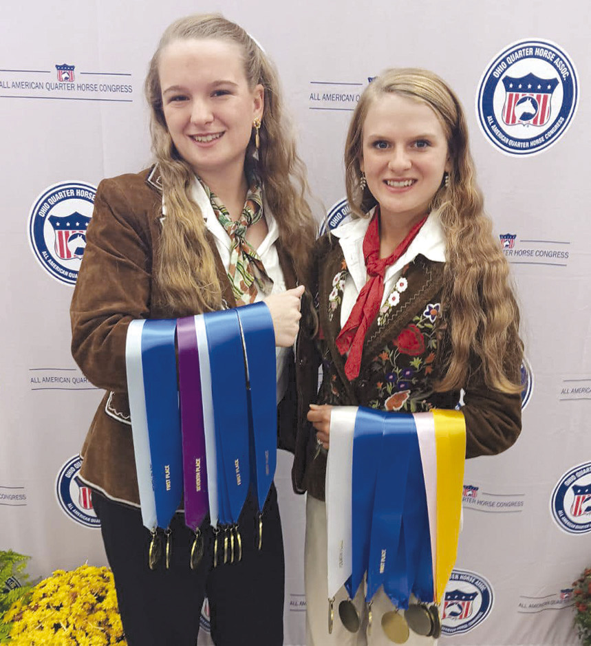 Courtesy Photo Faith Fry (l) and Grace Fry (r) hold the multiple medals they won at the All American Quarter Horse Congress recently in Ohio. The sisters are members of the Shackelford County 4-H club.