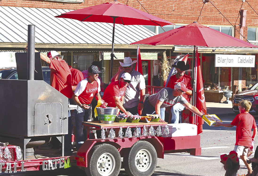 Doughnuts for the crowd. A member of the Class of 1993 gives away not candy, but a box of doughnuts to a spectator along the route. The float had a tailgate theme. Donnie Lucas /AlbanyNews
