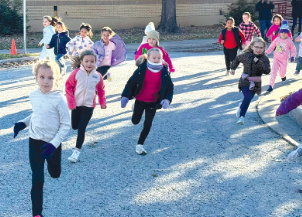 Nancy Smith Elementary students take o! from the starting line during the school’s first Jingle Run, where participants raced for a chance to win turkeys for their families.
