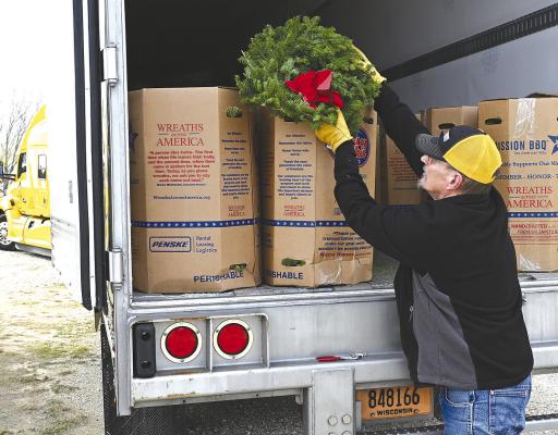 Reny Rsyhule, of Columbia, Maine, unloads hundreds of wreaths from his semi-truck, preparing for National Wreaths Across America Day this weekend. Volunteers will meet at the Albany Cemetery at 10 a.m. to start the event. DONNIE LUCAS / ALBANY NEWS