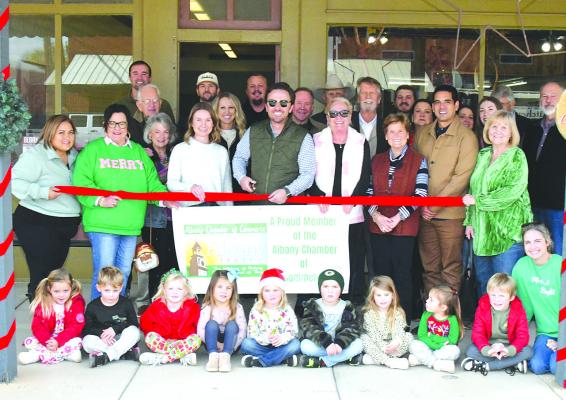 David Waller (c), new publisher and owner of The Albany News, cuts the ceremonial ribbon along with his wife Courtney and other members of his family during a Chamber of Commerce ribbon cutting last Friday. The new location of the newspaper office is in the downtown block at 128 South Main Street. DONNIE LUCAS / ALBANY NEWS