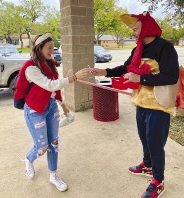Secondary principal Ezra Chambers greets Tatum Grady and other students arriving at school Tuesday morning dressed as a turkey after winning the dubious honor of being the 2023 “Turkey Teacher.” A fundraiser for the FCCLA, the competition broke a record, bringing in $870. Courtesy Photo