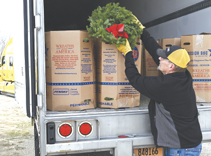 Reny Rsyhule, of Columbia, Maine, unloads hundreds of wreaths from his semi-truck, preparing for National Wreaths Across America Day this weekend. Volunteers will meet at the Albany Cemetery at 10 a.m. to start the event.
